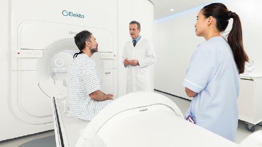 Patient sitting on Elekta Unity with a Doctor and Nurse